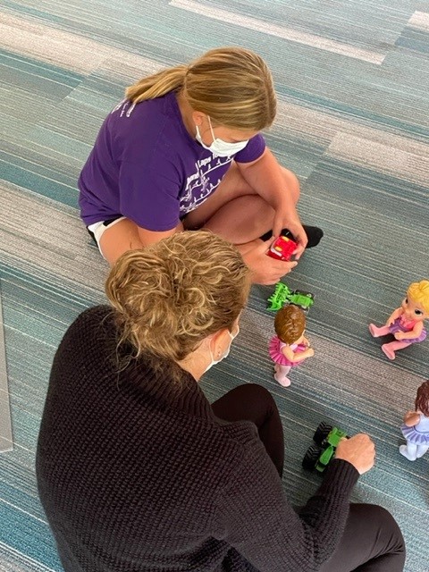 A woman and two children sitting on the floor